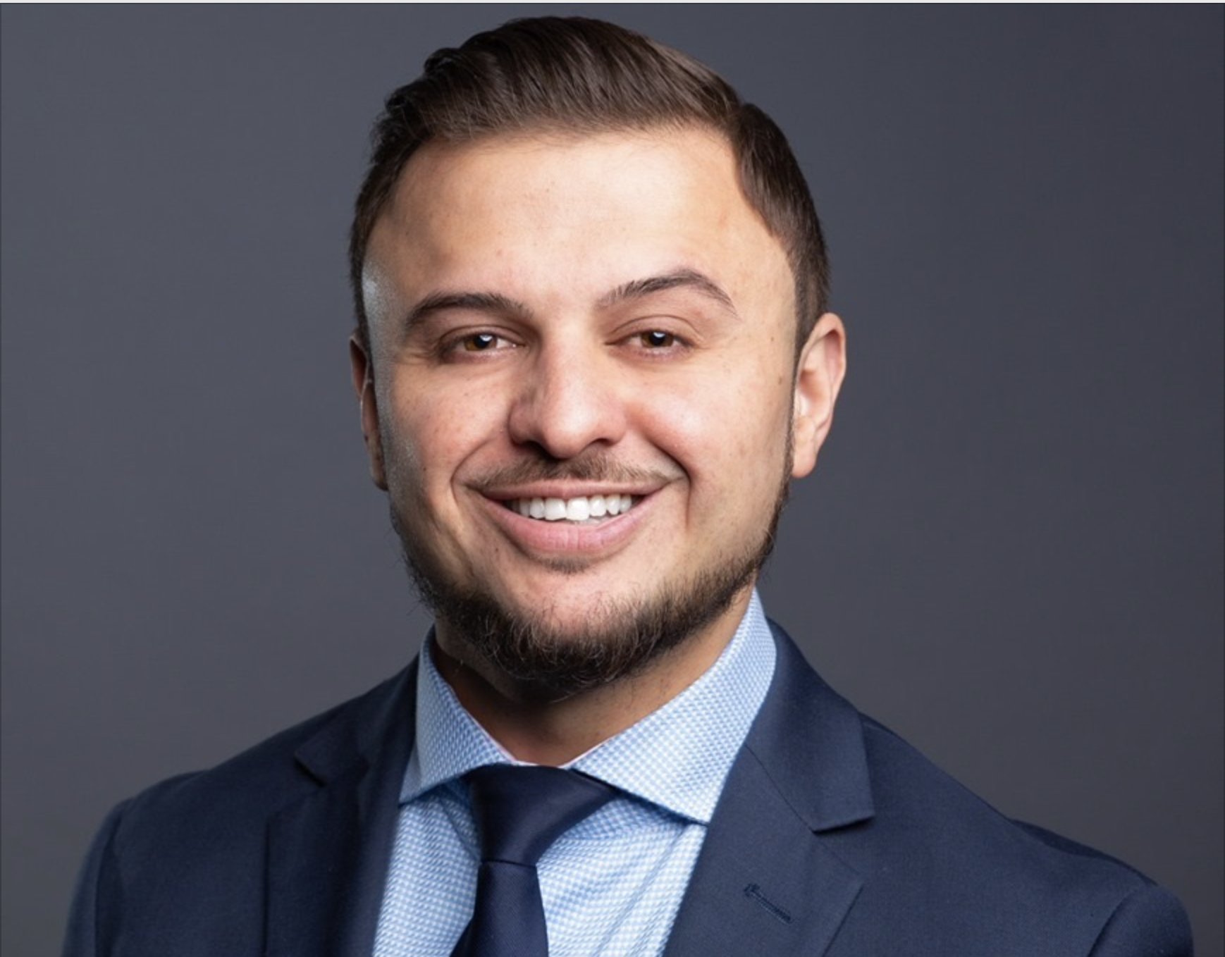 Nick Sakha, a smiling man in a suit